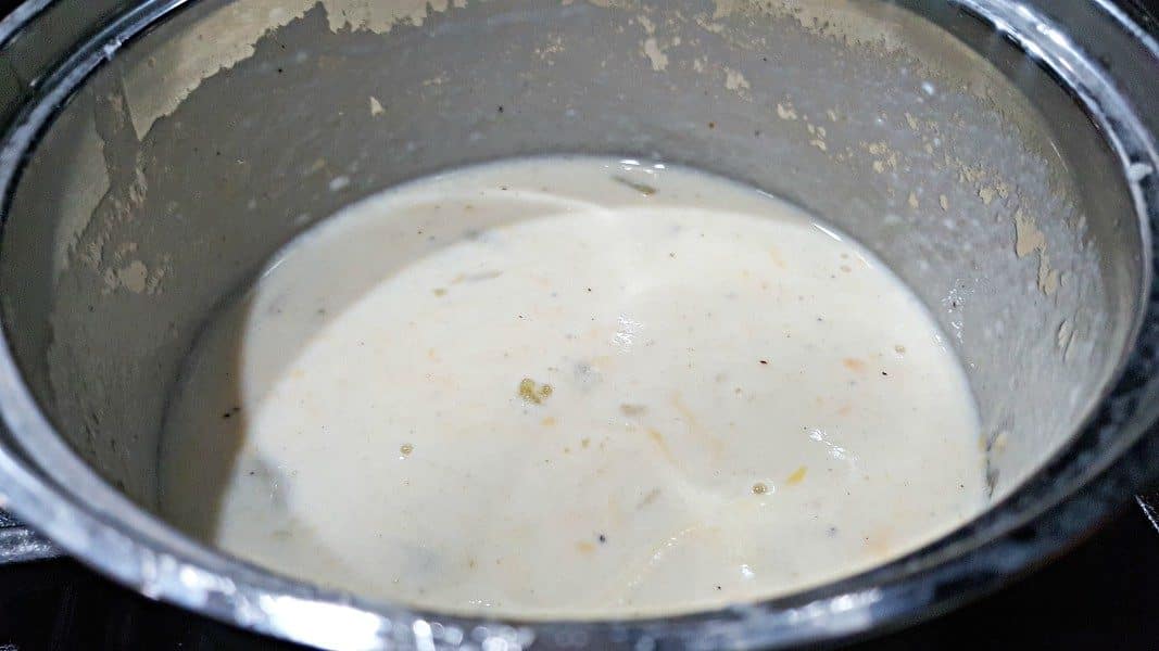 cheesy green chili sauce cooking in a sauce pan