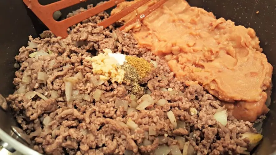 ground beef and onion with refried beans and seasonings.