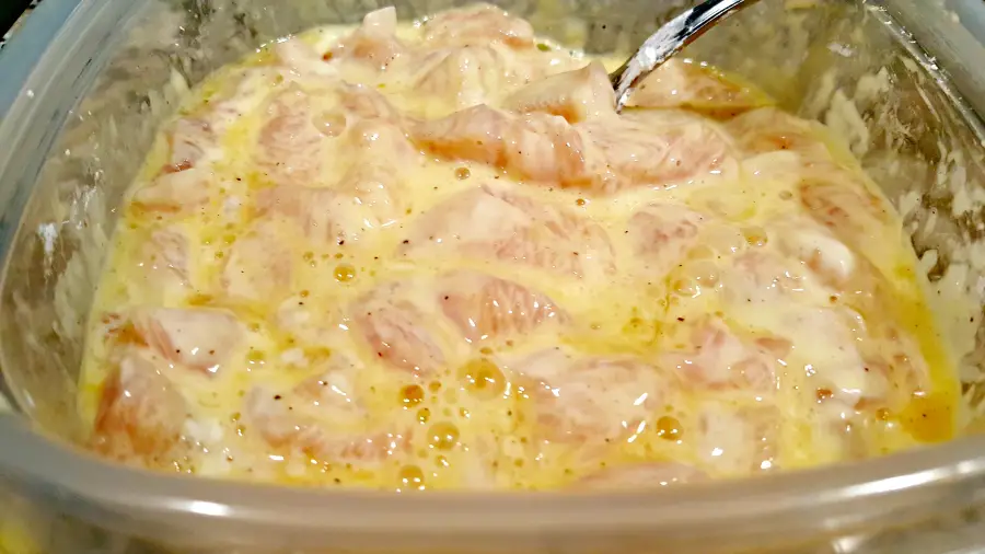 chicken and egg mixture in a dish with a spoon