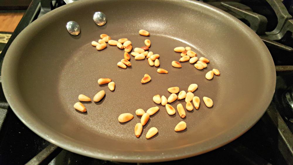 pine nuts cooking in a frying pan.