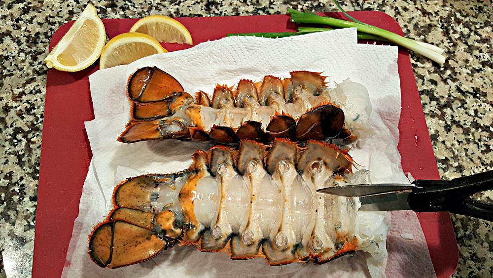 kitchen shears cutting the underside of the lobster tails lengthwise