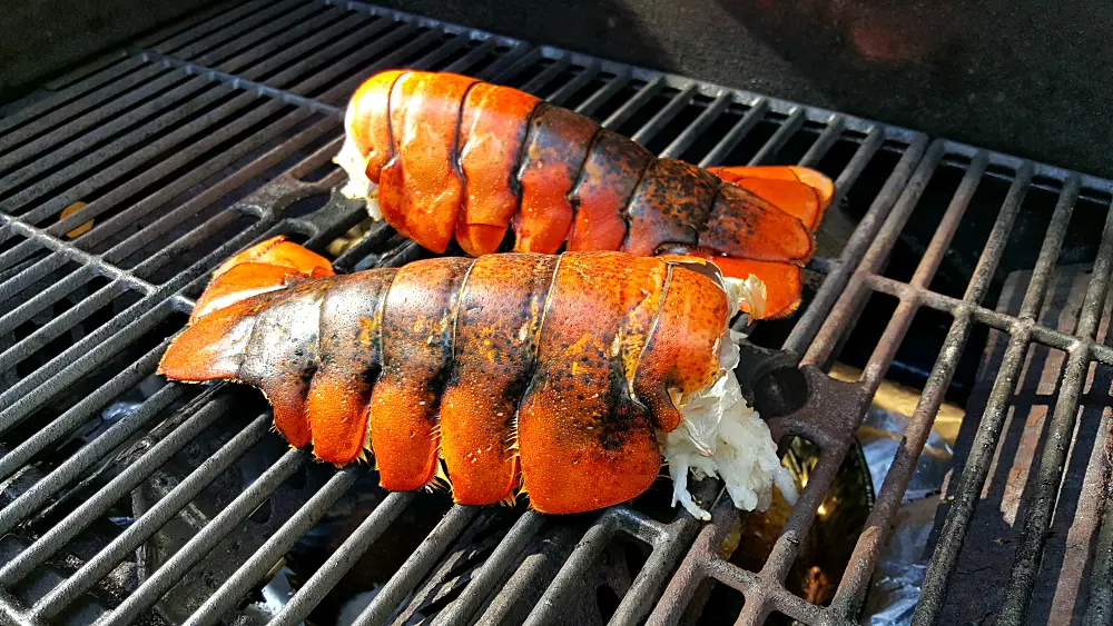 two lobster tails on a grill