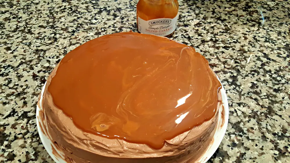a chocolate cake with chocolate frosting topped with salted caramel sauce