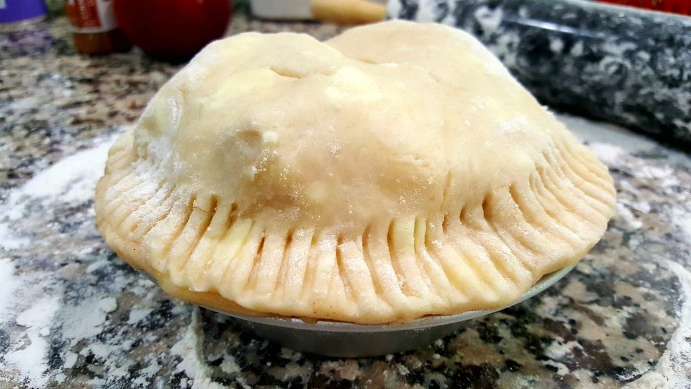 an unbaked mini pie crust in a 6" pie pan with slits cut in the top crust