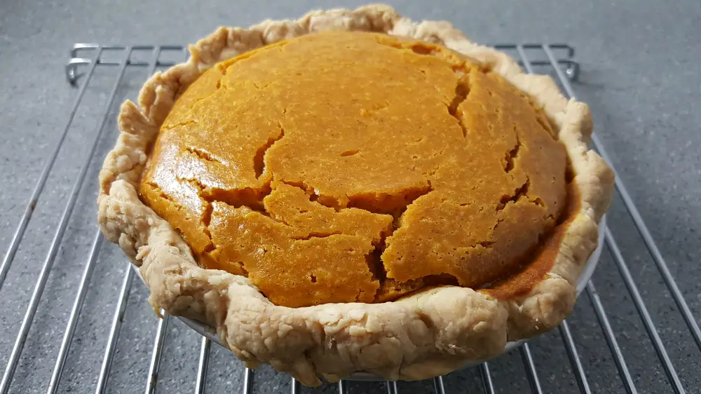 Small Pumpkin Pie cooling on a wire rack.