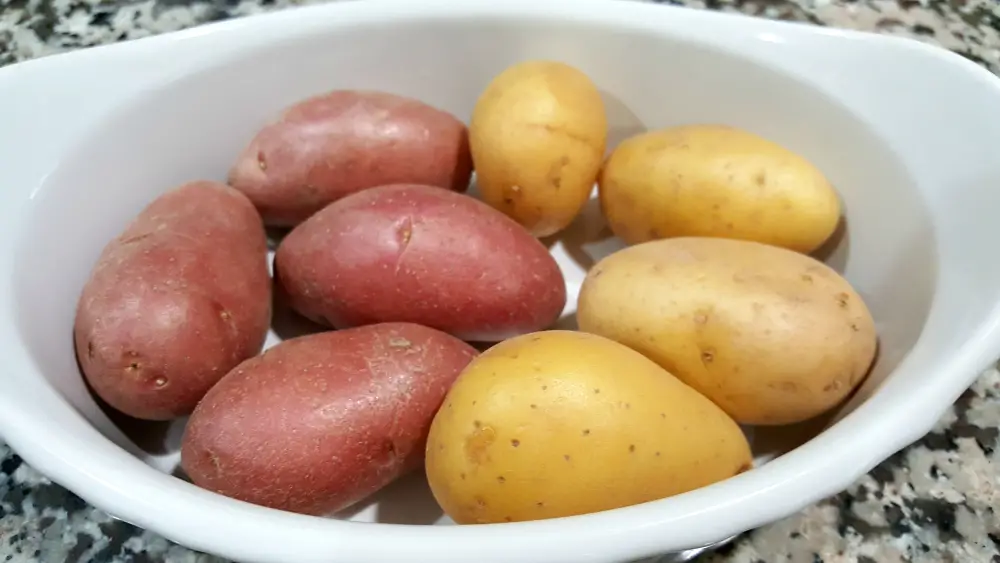 eight red and yellow fsmall potatoes in a dish