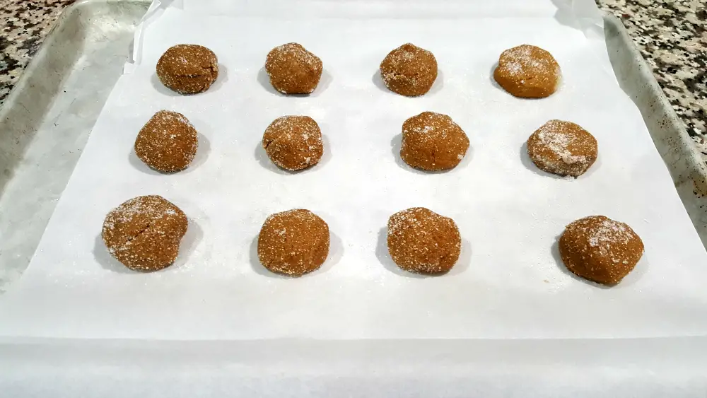 cookie dough balls on a parchment lined baking sheet.