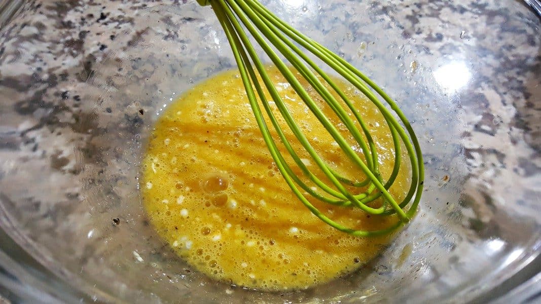 egg, pepper, baking powder, oil, and seasoned salt mixed in a bowl.