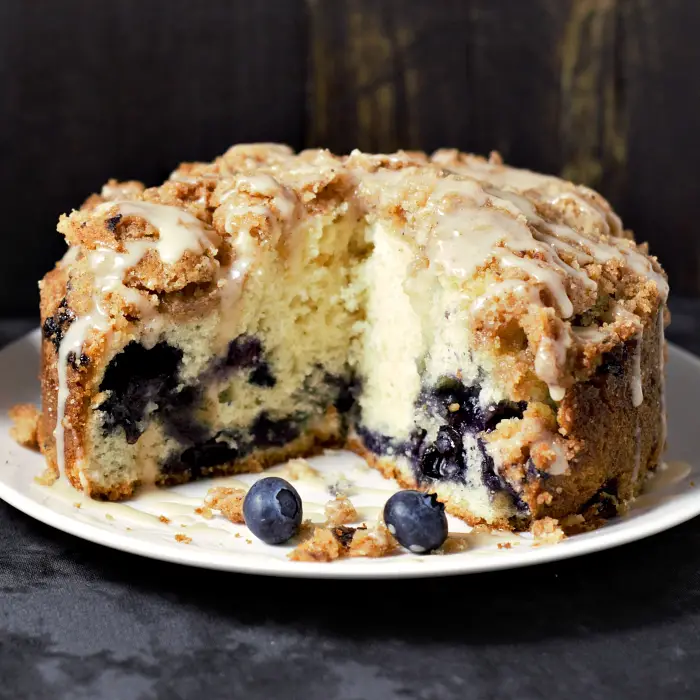 Easy Blueberry Breakfast Cake with streusel crumble and glaze drizzled over it.