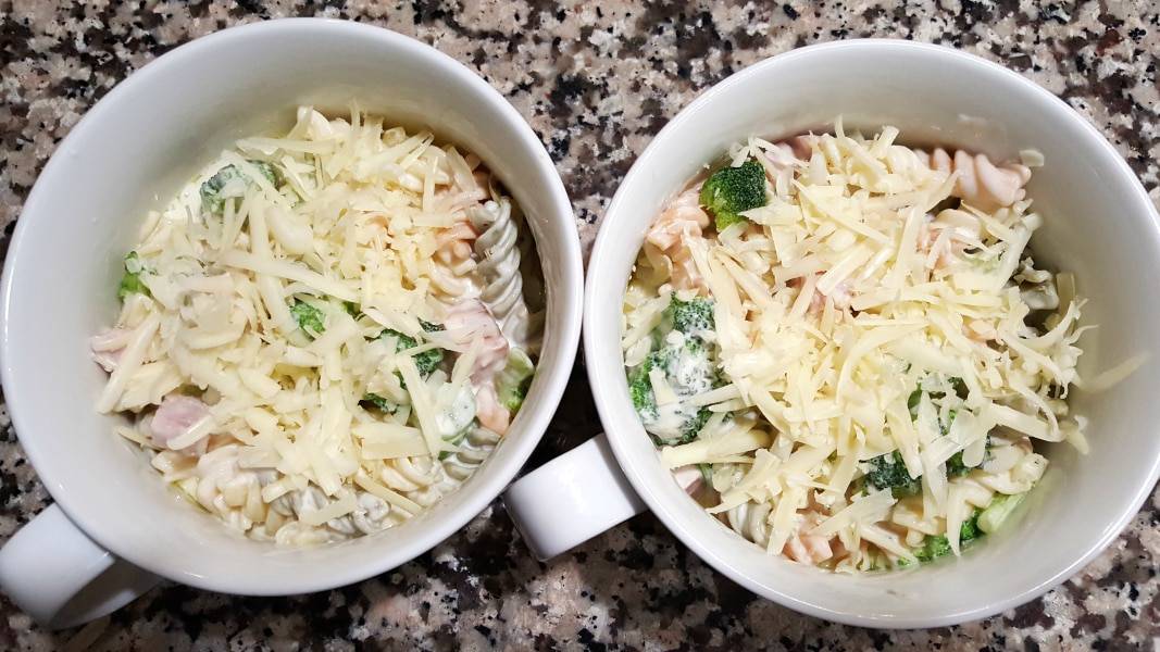 Cheesy Broccoli Pasta Bake topped with shredded cheese.