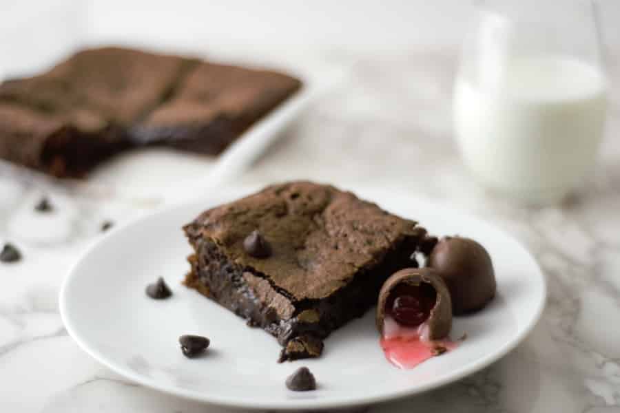 Chocolate Covered Cherry Cordial Brownies in a pan and one on a plate
