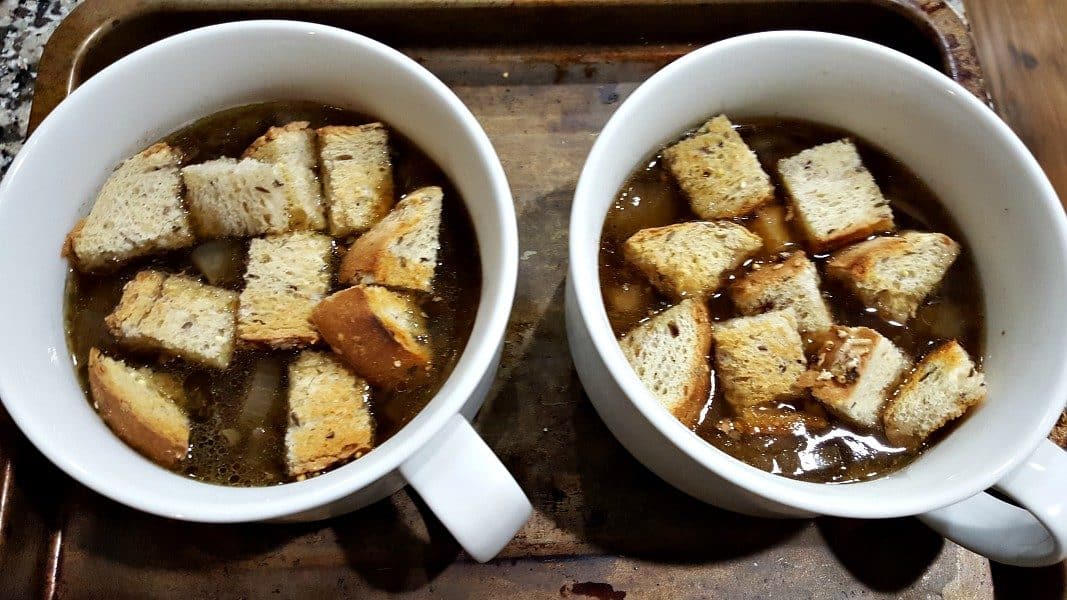 onion soup and croutons in two soup bowls