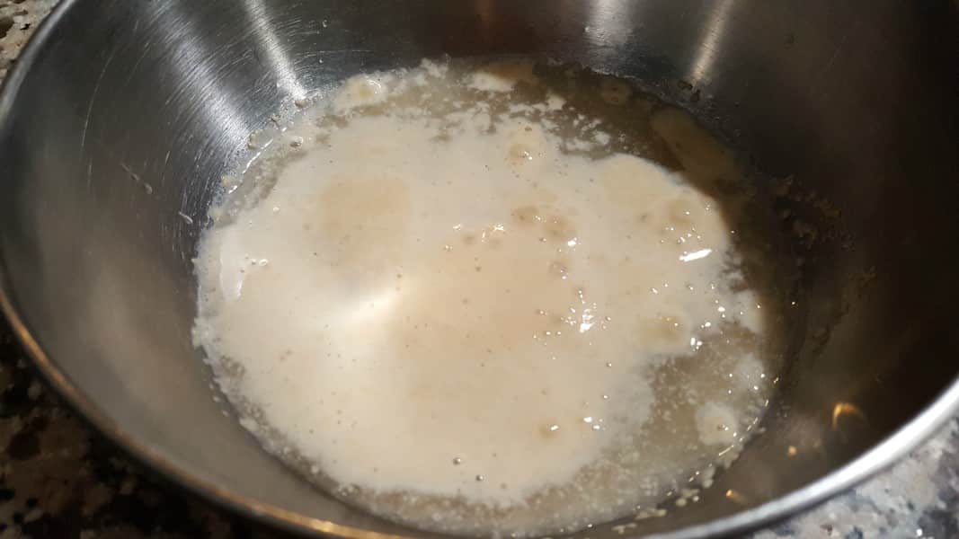 yeast, sugar, and water activating in a bowl.