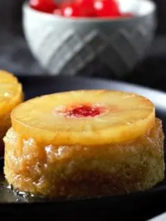 Individual Pineapple Upside-down Cakes on plates.