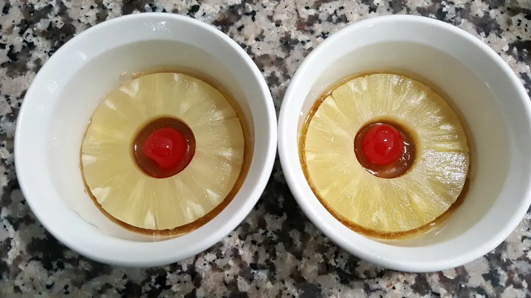pineapple rings and cherries in two ramekins.
