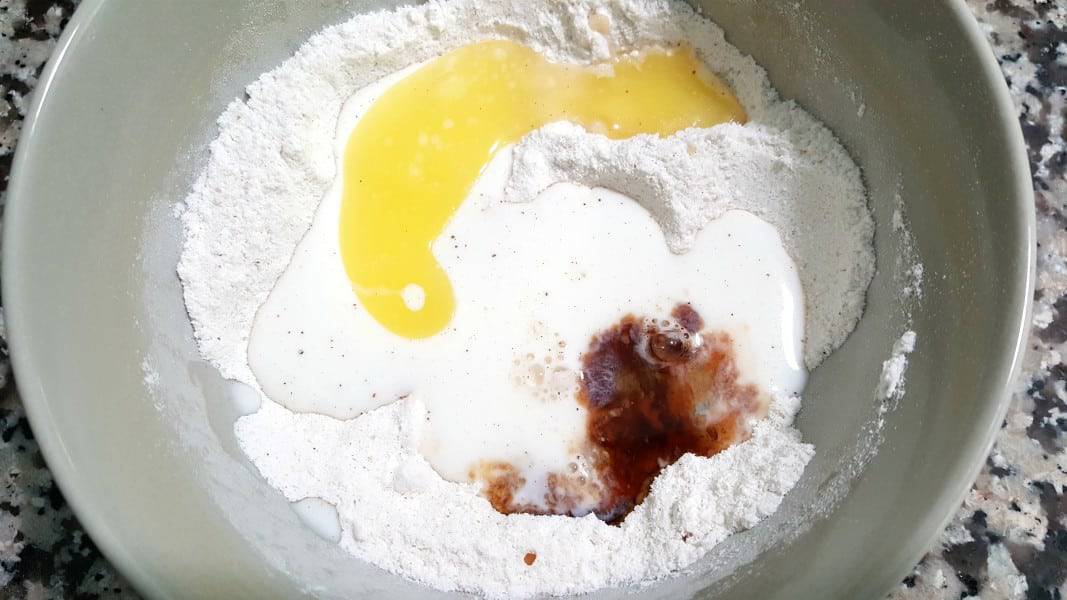 flour, sugar, baking powder, salt and nutmeg, butter, milk, and cinnamon in a bowl.