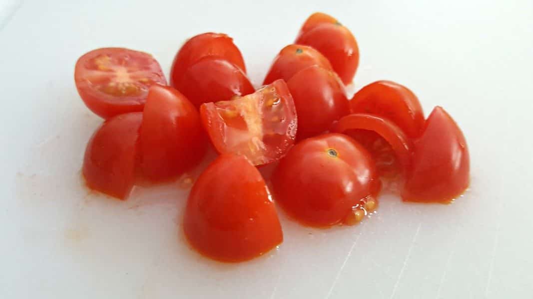 a pile of small cherry tomatoes diced into pieces