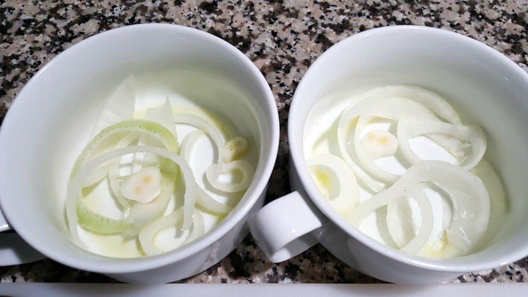 two bowls with sliced onions in the bottom
