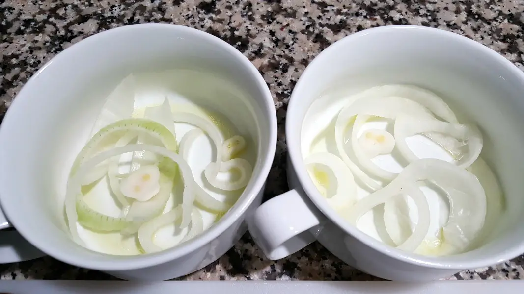 two bowls with sliced onions in the bottom.