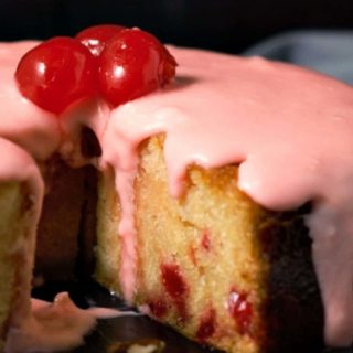 Glazed Cherry Almond Cake with a slice missing.