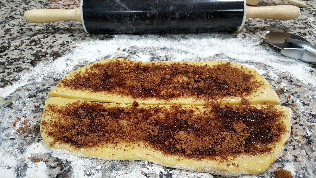 dough rolled out, cut in half, topped with butter and cinnamon sugar mixture