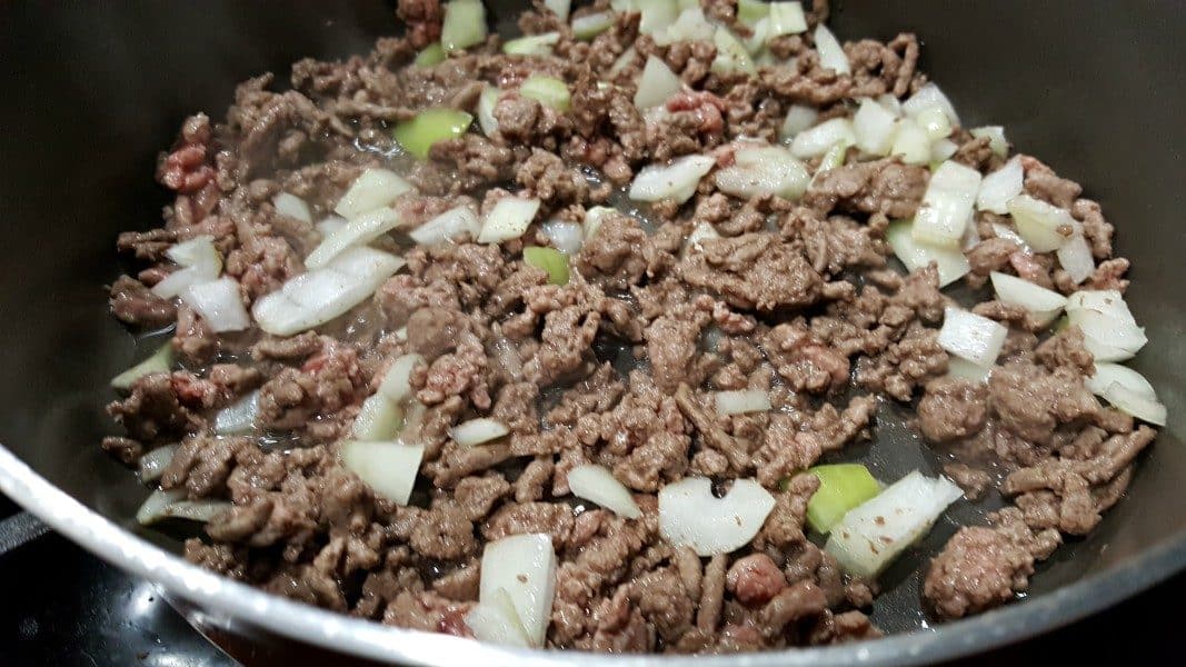ground beef and onion frying in a pan