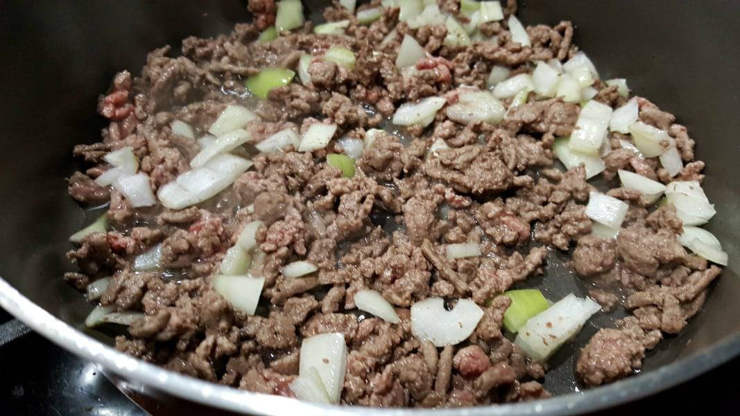 ground beef and onion frying in a pan.