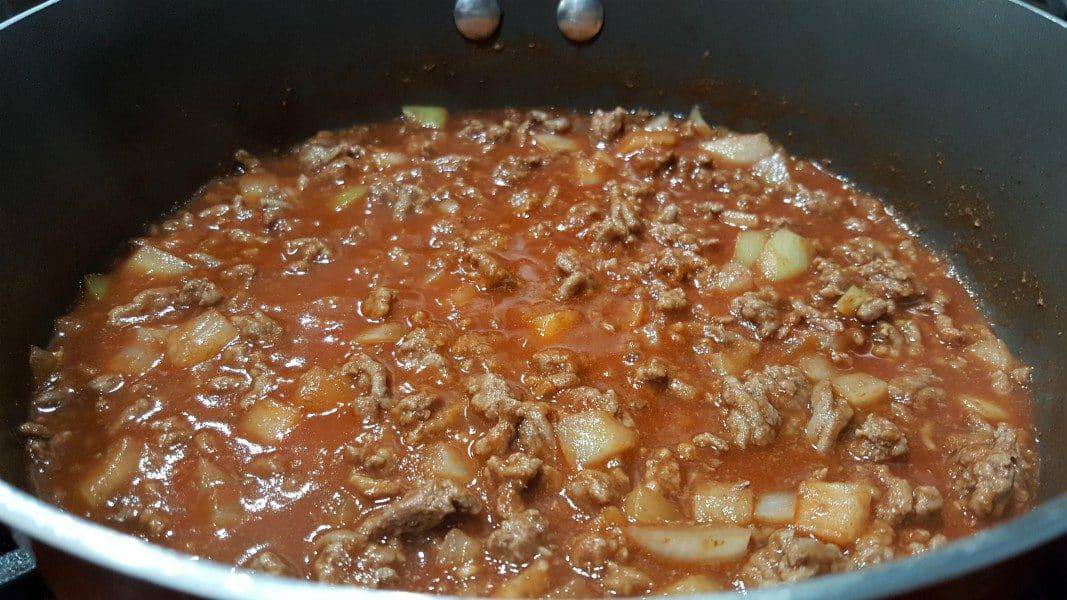 ground beef, onion, garlic, tomato paste, water, Worcestershire sauce, brown sugar, and salt cooking in a pan