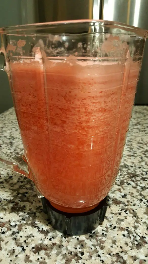 a blender filled with pink blended watermelon sangria with Moscato.