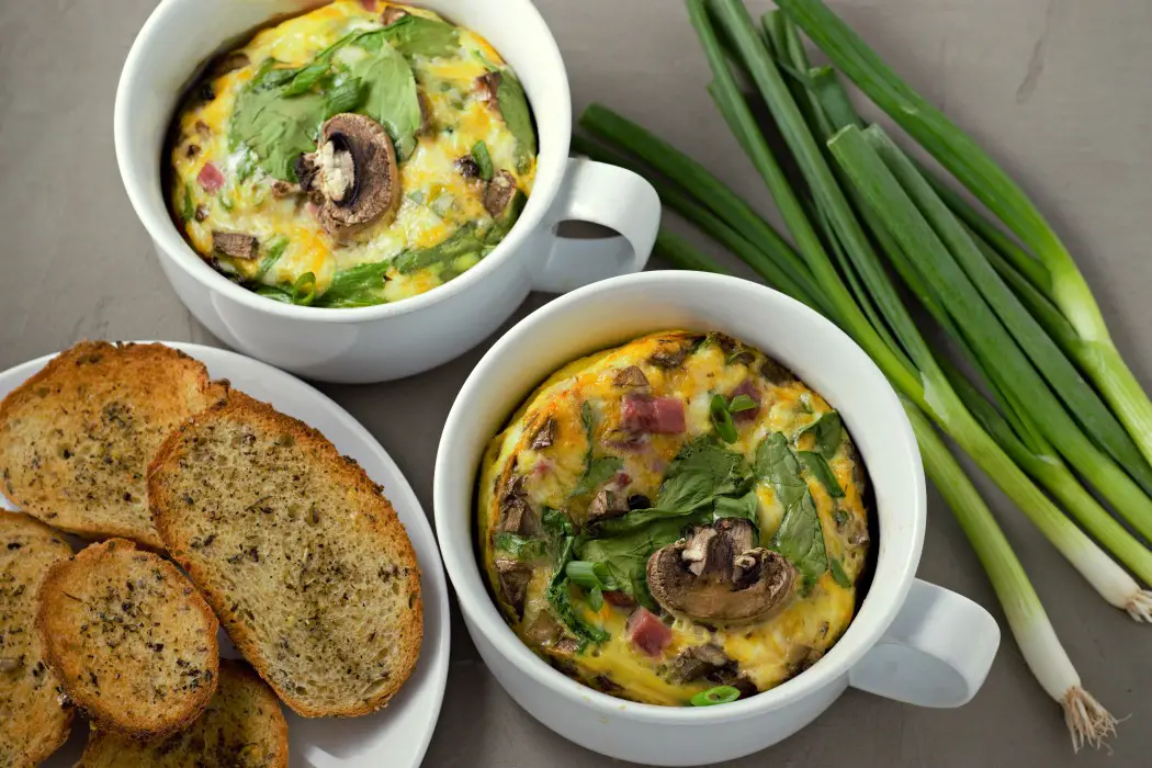 Low-carb Baked Cheesy Ham Spinach Omelets in casserole dishes.
