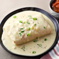 Crispy Chicken Chimichanga for 2 topped with Cheesy Green Chili Sauce #chimichangas #ChickenChimichangas #DinnerForTwo #LunchForTwo #RecipesForTwo #MexicanFood #GreenChiliSauce