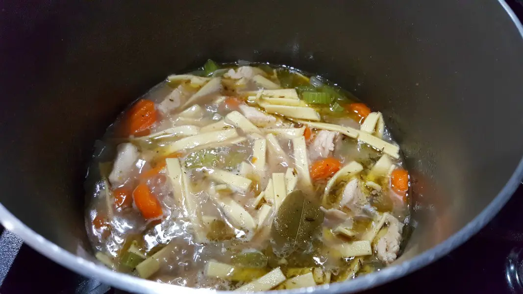 One Pot Chicken Noodle Soup from scratch cooking in a large sauce pan.