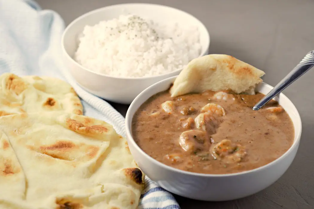 a bowl of Shrimp Korma, rice, and naan bread.