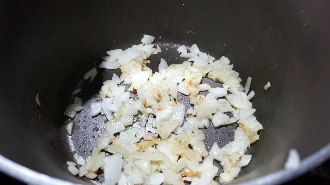 chopped onion cooking in a medium sauce pan.
