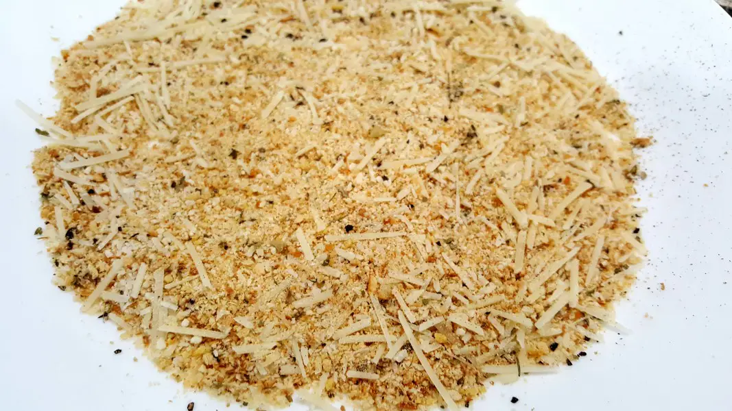bread crumbs, parmesan cheese, salt and pepper mixed on a plate.
