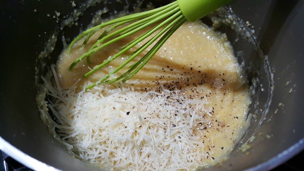 whisking parmesan, butter, salt, and pepper into polenta in a sauce pan