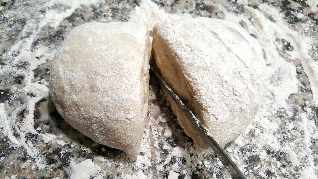 cutting pizza dough in half
