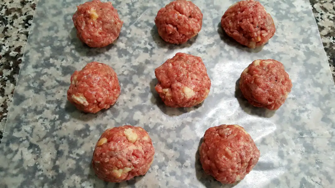8 uncooked Swedish meatballs on wax paper.