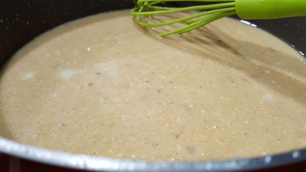 Swedish meatball sour cream gravy cooking in a skillet.