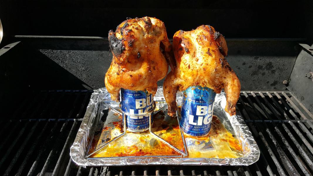 two Cornish game hens grilled over beer cans.