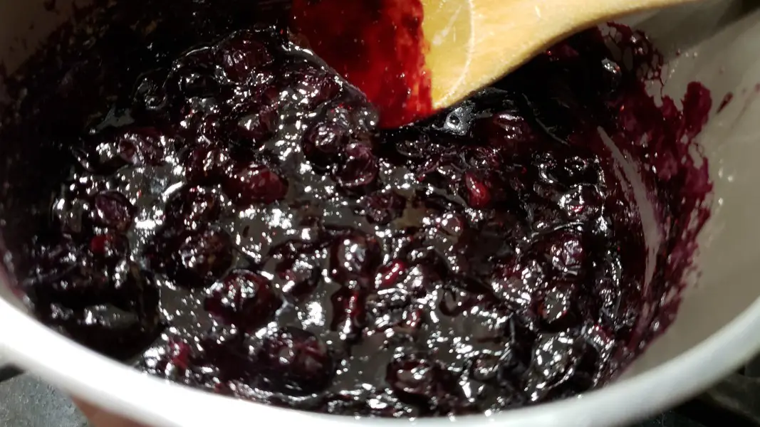 blueberry sauce for cheesecake cooking in a pan.