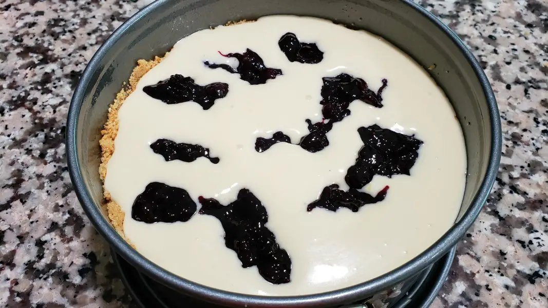 blueberry swirl sauce dropped randomly into lemon cheesecake filling in a 7 inch springform pan.