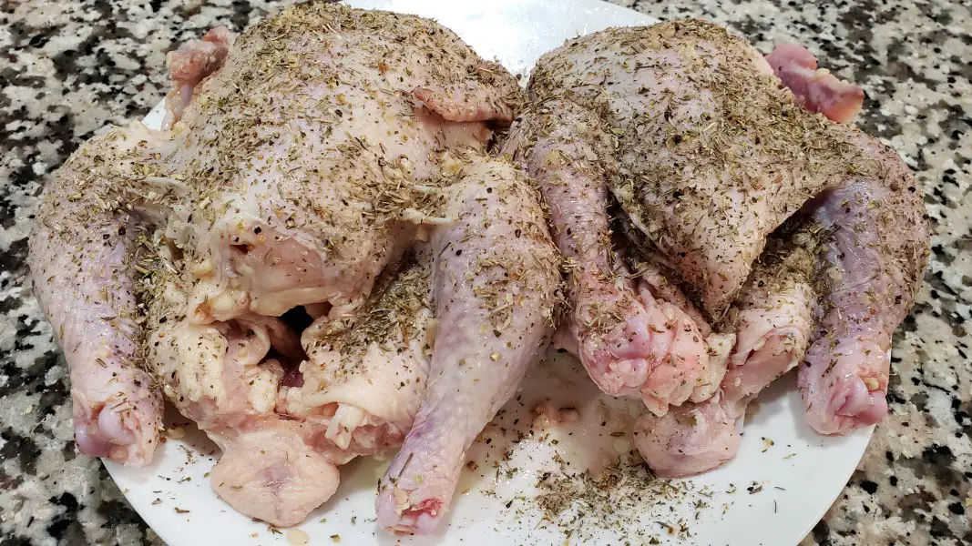 two cornish hens with herbs sprinkled on.