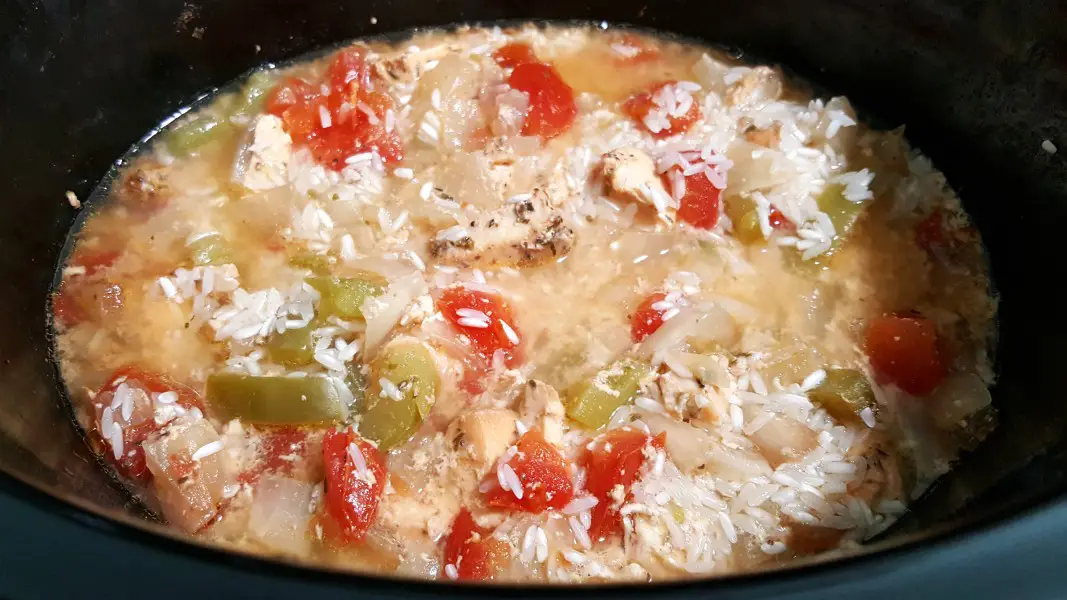 rice added to Jambalaya ingredients in a slow cooker crock pot.