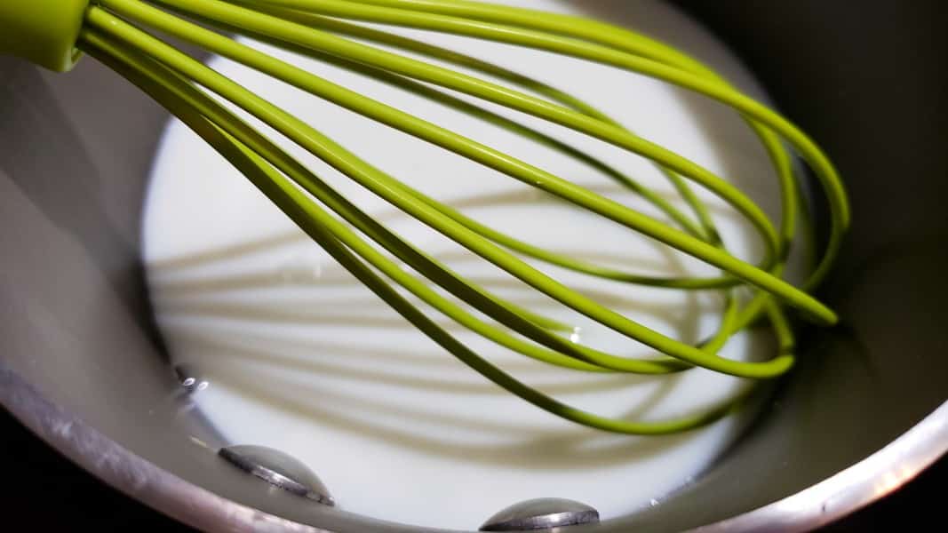 milk and sugar reducing in a saucepan with whisk.