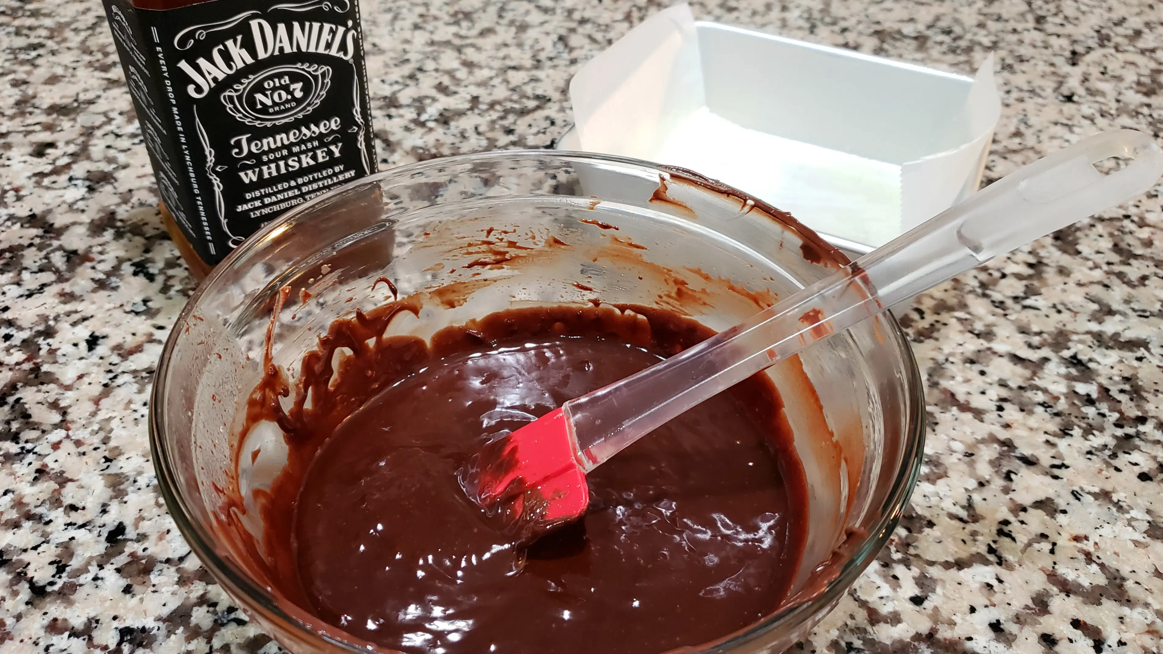 whiskey fudge batter mixed in a bowl with red spatula.