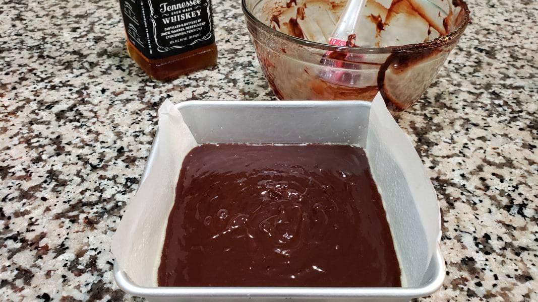 whiskey fudge batter poured into a 6 x 6 cake pan.