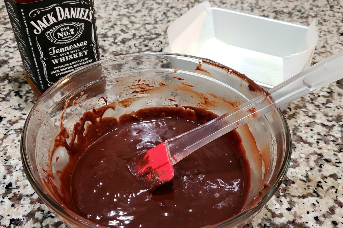 whiskey fudge batter mixed in a bowl with red spatula.