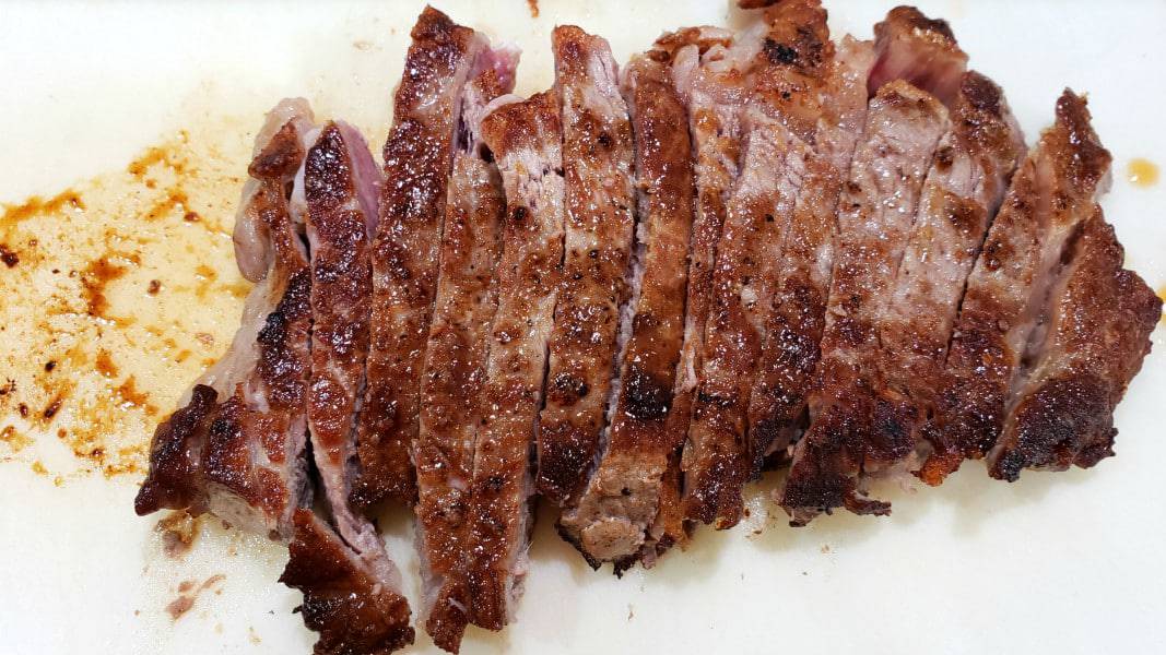 ribeye steak sliced on a cutting board.