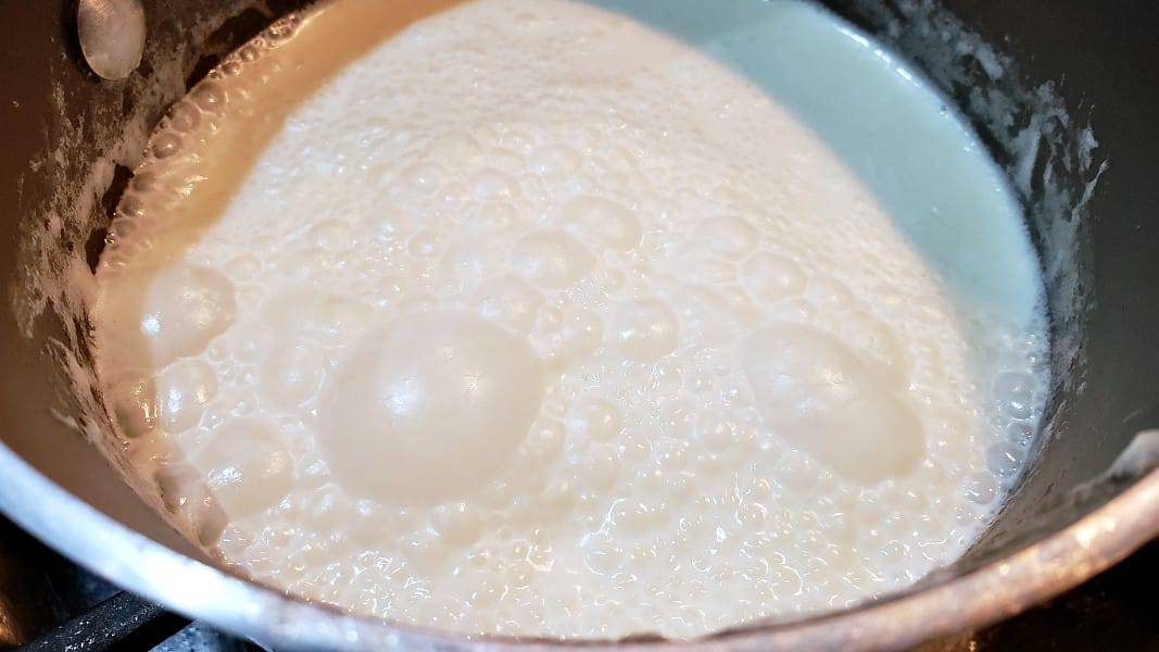 heavy cream simmering in a sauce pan.